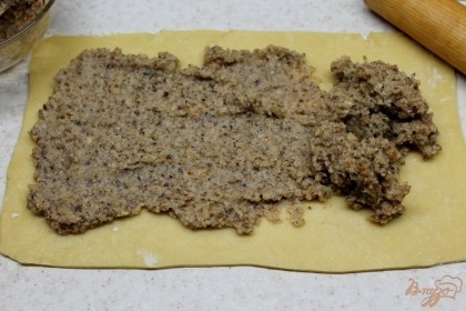 Тесто раскатываем толщиной 2 мм. На лист теста выкладываем начинку и распределяем равномерно по всей поверхности.