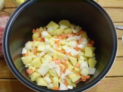 Складываем на смазанное дно чаши картофеля слой, овощи половину.