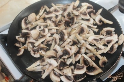 На растительном масле обжарить грибы, через 5 минут добавить колбасу и специи.