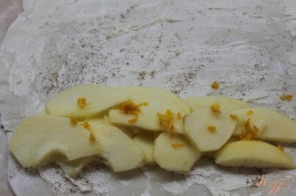 На край теста положить яблоко нарезанное дольками и посыпать цедрой апельсина. Закрутить тесто в трубочку и хорошо закрыть края.
