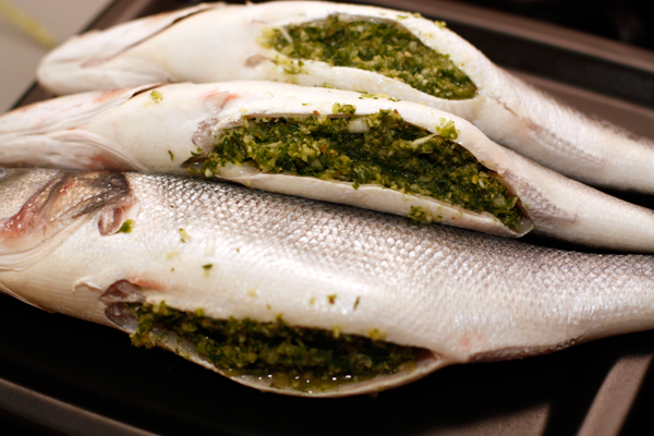 Плотно набить брюшки рыбы получившейся смесью. Можно обвязать рыбу кулинарной нитью, чтобы начинка лучше удерживалась внутри.