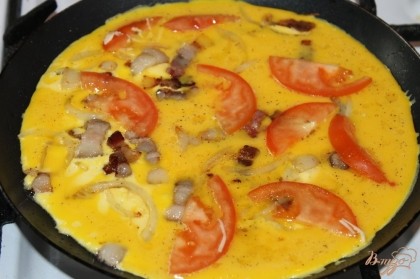Залить смесь с яиц и молока, сверху положить помидор и посыпать сыром. Накрыть крышкой и жарить на маленьком огне.
