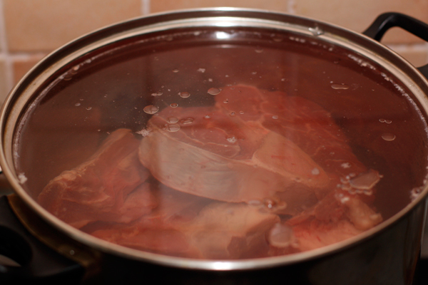 Мясо положите в кастрюлю и залейте тремя литрами холодной воды. Кастрюлю нужно подобать так, чтобы мясо было покрыто водой.<br>  На большом огне доведите мясо до кипения, а затем уменьшите огонь до самого маленького, чтобы бульон почти не булькал. Очень тщательно снимайте пену до тех пор, пока она не перестанет образовываться. Варите мясо без крышки в течение 6 часов. 