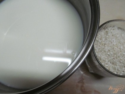 В кастрюлю с толстым дном вылить молоко и довести до кипения. Всыпать рис (желательно использовать рис для ризотто) и варить до готовности.
