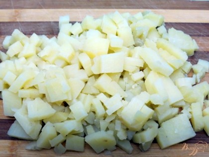Картофель варим в кожуре с добавлением столовой ложки соли. Охлаждаем и нарезаем мелкими кубиками.