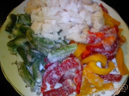 Подготовить замороженные овощи: нарезанную небольшими кусочками цветную капусту красный болгарский перец - соломкой и кусочки стручковой фасоли. Добавить в ризотто и потушить всё вместе 10-15 минут.