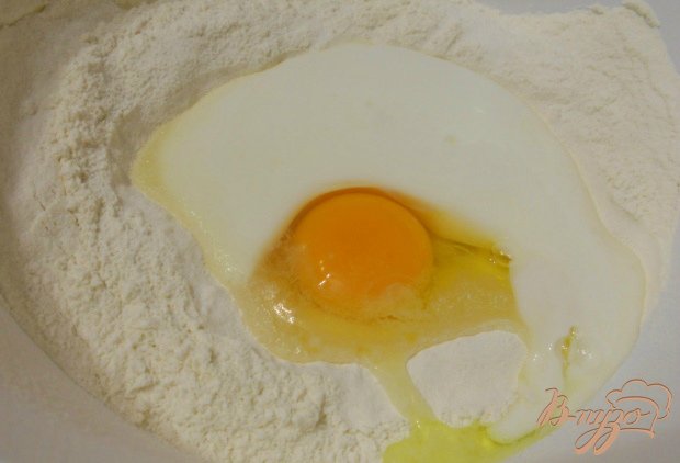 Муку просеять в глубокую миску, сделать углубление. Влить теплый кефир, добавить яйцо, соль, сахар, соду.