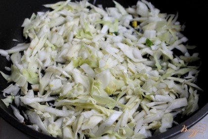 Чистим и режем репчатый лук, шинкуем капусту и выкладываем овощи на сковородку с разогретым подсолнечным маслом. Солим и обжариваем пару минут.