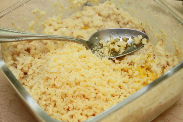 В отдельной миске слегка взбейте яйца, насыпьте соли, положите творог, разотрите всё в однородную массу. Слегка остуженную капусту размельчите в мельнице и смешайте с творожной массой. Подмешайте масло и сыр. Масло можно взять любое растительное, или сливочное.