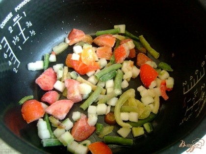 В чашу мультиварки налейте постное масло, выложите слой овощной смеси, немного их посолите. Я использовала замороженную смесь «Лечо».