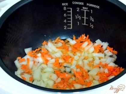 В чашу мультиварки наливаем растительное масло, высыпаем морковь и лук, включаем режим жарки.