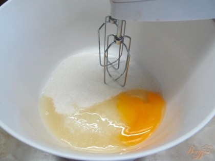 В чаше миксера на большой скорости взбить сахар с яйцом и солью до белого цвета.