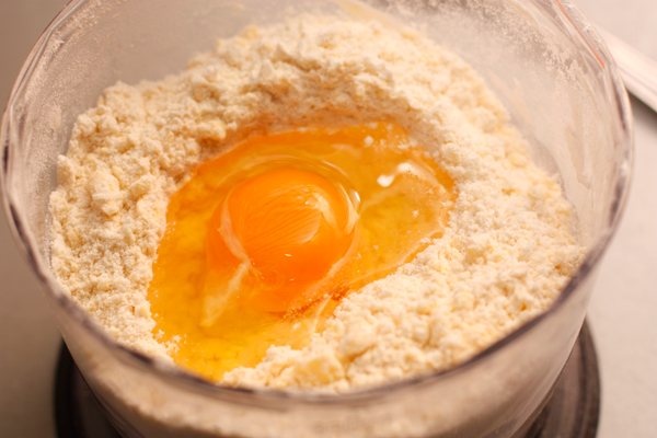 В мучную смесь добавьте яйцо и быстро перемешайте, чтобы тесто не успело нагреться. Если крошки все же останутся, добавьте ложку ледяной воды.