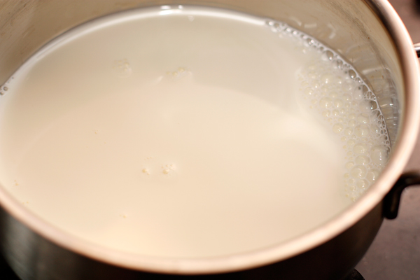 Нагрейте молоко в кастрюле. Можете положить туда разрезанный вдоль стручок ванили, а затем вынуть.