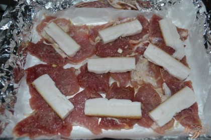 Сверху мяса разложить сало нарезанное пластинами. (Это для того, чтобы мясо было сочным и не подгорело).