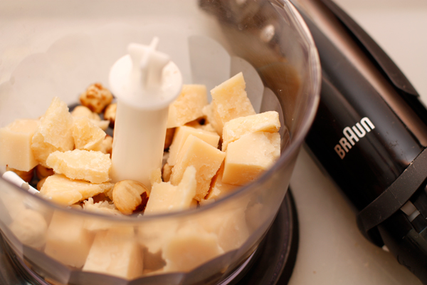 Орехи положите в блендер, туда же положите нарезанный кубиками сыр.