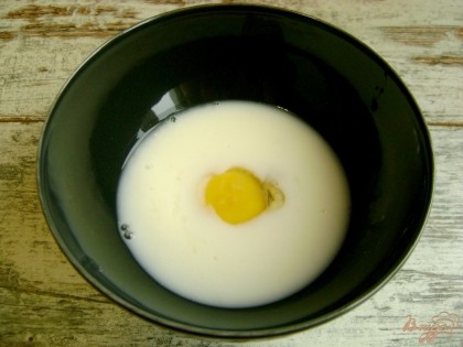 Чтобы приготовить яичные блинчики, смешайте яйцо и молоко.