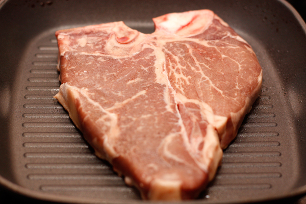 Размороженное мясо подержите полчаса при комнатной температуре, затем сильно разогрейте сковороду-гриль и положите на нее стейк.  Не забудьте предварительно посолить и поперчить мясо.