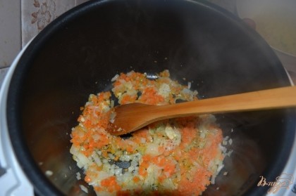 Через несколько минут отправить к луку пропущенный через пресс чеснок и половину моркови. Жарить до золотистости.