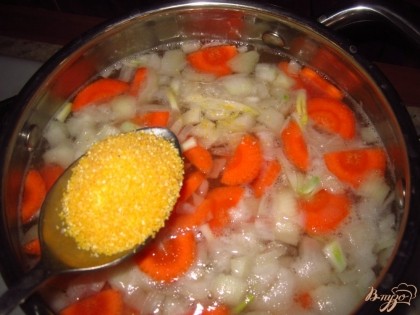 Налейте в кастрюлю куриный бульон, добавьте овощи и варите до полуготовности. Потом добавьте кукурузную крупу, соль и варите суп до готовности.