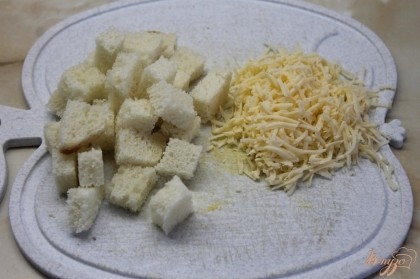 Приступаем к приготовлению гренок: хлеб белый нарезать средним кубиком, сыр натереть на мелкую терку.