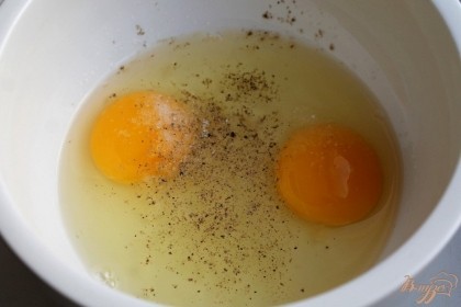 В миску вбиваем яйца, добавляем соль, сахар и черный молотый перец. Взбиваем до появления пены.