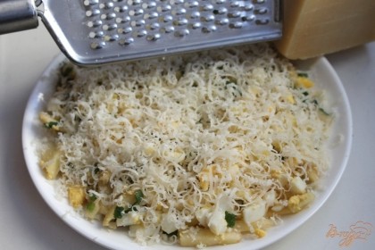 Салат перекладываем на плоскую тарелку. Натираем твердый выдержанный сыр и посыпаем салат.