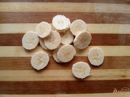 Банан тонко нарежьте на кусочки.