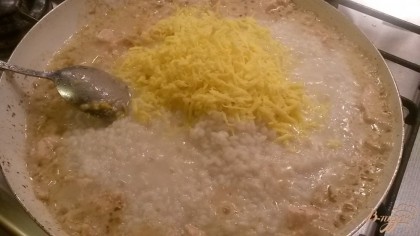 Готовый рис добавляем в курицу, туда же кладем сыр, цедру и сок лимона, перемешиваем и даем покипеть минуты 2-3. Обязательно приправляем блюдо солью и черным перцем. В конце приготовления можно добавить любую зелень на ваш вкус.