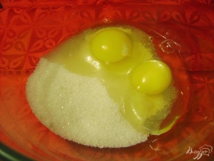 В глубокой посуде соединяем куриные яйца с сахаром.