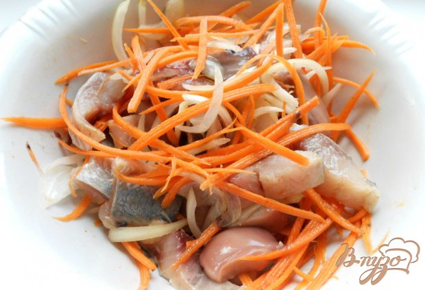 Морковь натереть на терке для корейской моркови, лук порезать тонкими полукольцами. Смешать с кусочками сельди.