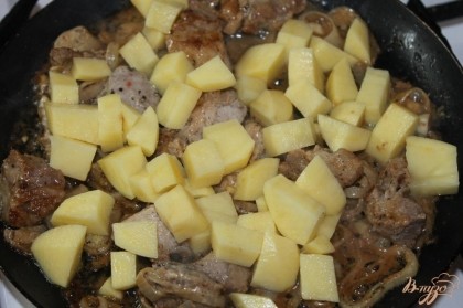 Когда свинина про тушилась слегка добавляем картофель нарезанный средним кубиком и обжариваем еще 5 - 7 минут.