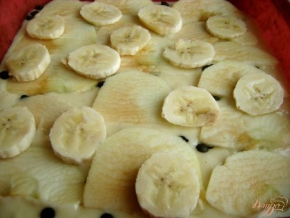 Яблоко очистите от кожуры, порежеьте плоды полукругами. Банан также очистите, нарежьте его кружочками. Выложите фрукты в 1-2 ряда на тесто.
