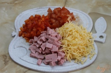 Выполняем нарезку: колбаса, помидор, перец нарезаем на мелкий кубик, сыр натираем на мелкую терку.