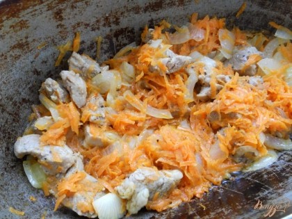 Поместить мясо в кипящее масло, перемешать. Обжаривать до небольшой румяной корочки, после чего добавить лук и морковь. Посолить. Готовить до румяности лука.