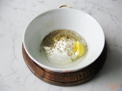 В миску кладём желток отваренного яйца, лимонный сок, горчицу, сметану, растительное масло и сухой базилик.