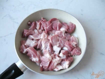 Свинину моем и нарезаем небольшими кусочками. Мясо кладем на горячую сковороду с подсолнечным маслом.
