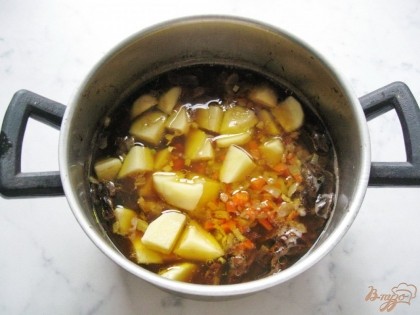 Когда перловка и грибы будут почти готовы, кладем в кастрюлю нарезанный картофель, лук и морковь. Добавляем воду, лавровый лист. Солим и перчим по вкусу.