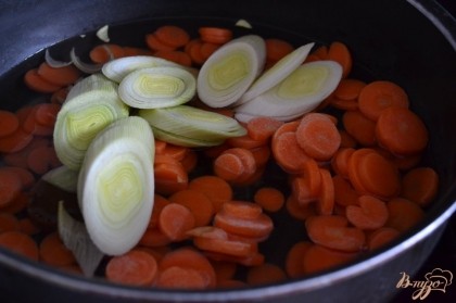 С глубокой сковороде в воде или бульоне отваритьв течении 10 минут морковь и порей.