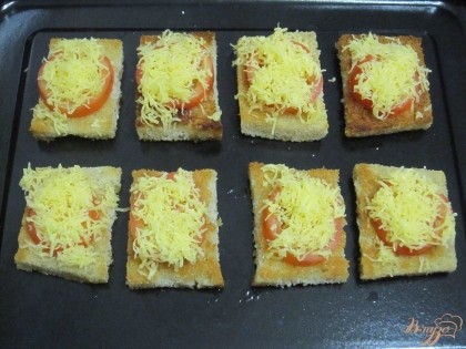 На ломтики хлеба выложить помидоры и посыпать тертым сыром. Запекать в духовке 5-7 мин.