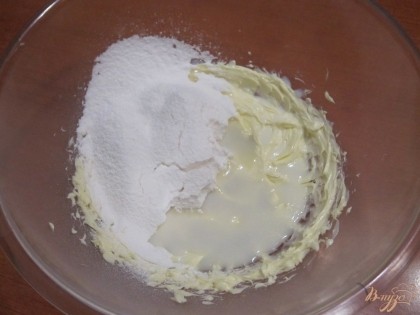 Приготовить крем. В миске взбить мягкое сливочное масло. Добавить молоко, ванильную эссенцию и половину сахарной пудры.