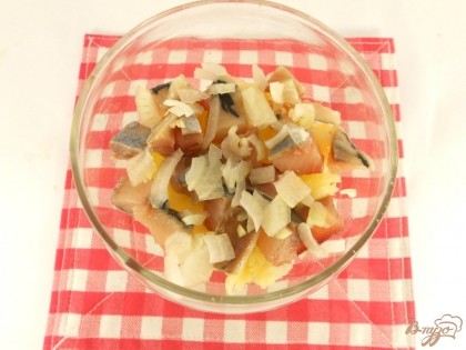 Салат выкладывать слоями. В креманку или салатник первым слоем выложить натертый на крупной терке картофель. На него порезанное мелкими кубиками филе сельди и порезанный мелко репчатый лук. Смазать майонезом.