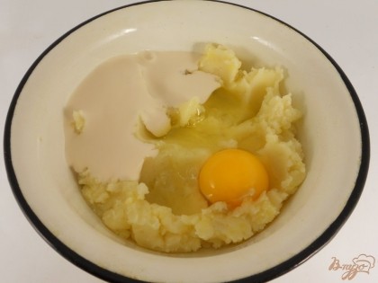 Толченый картофель немного остудить. Добавить сырое яйцо и кефир или ряженку.