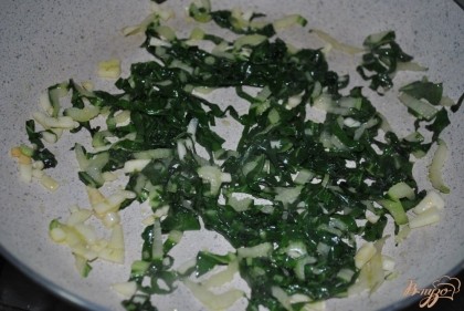 Обжарить ботву и чеснок на растительном масле 2-3 минуты, чтобы зелень уменьшилась в размере в 2 раза