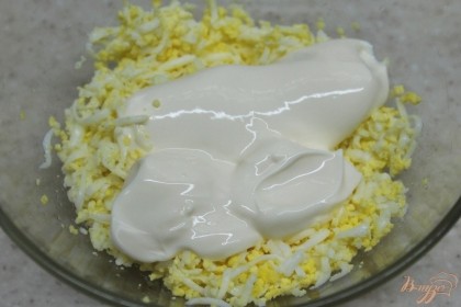 К яйцам добавляем мягкий плавленный сыр и перемешиваем.