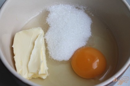 В пиалу насыпаем сахар, добавляем сливочное масло и яйцо. Все ингредиенты перемешиваем.