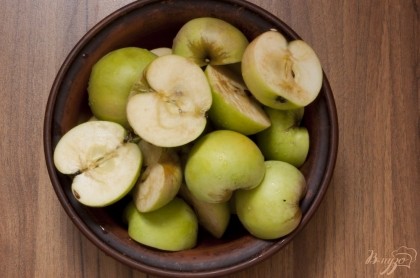 Яблоки промойте, разрежьте на 2-4 части, удалите плодоножки. Серединку не вырезайте - она придает особенный вкус, кожуру тоже не срезайте, иначе яблоки могут превратиться в кашу.