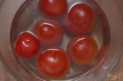 Надрежьте помидоры крестообразно на кончиках и залейте кипятком на минуту-две. Слейте воду.