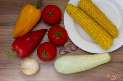 Подготовьте отварную кукурузу, кабачок молодой, перцы разных цветов, репчатый лук, чеснок, спелые помидоры.