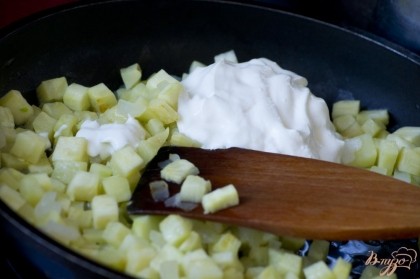 Посолите, добавьте к овощам на сковородку сметану. Перемешайте. Уменьшите огонь и тушите 7-10 минут.